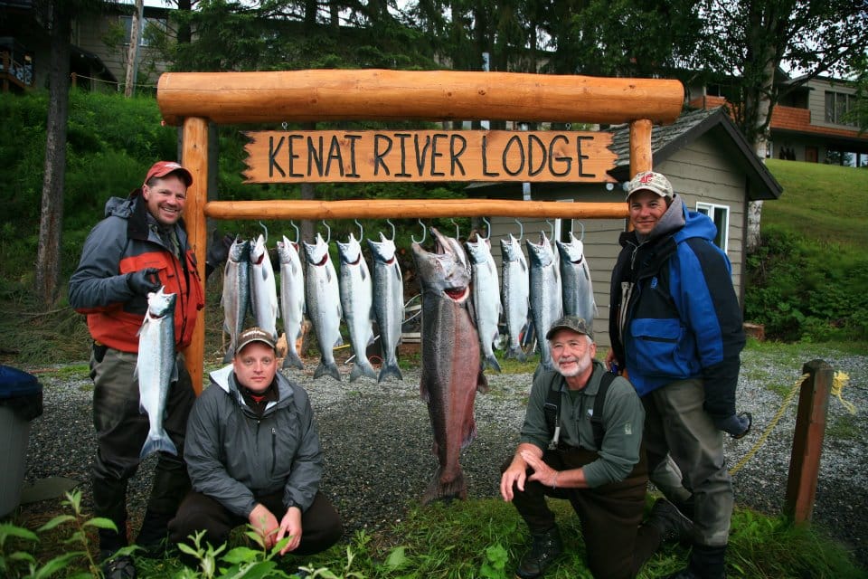 Four men showing their catch of many fish